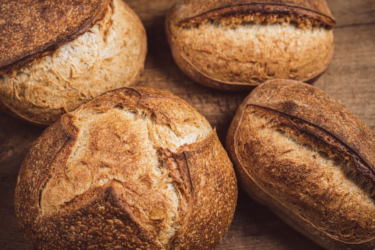 4 loaves of golden brown loaves of bread showing round and oval shapes - Hostess At Heart