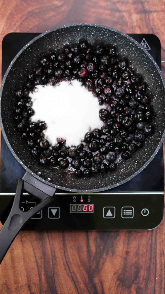 White sugar added to fresh blueberries in a skillet over heat - Hostess At Heart