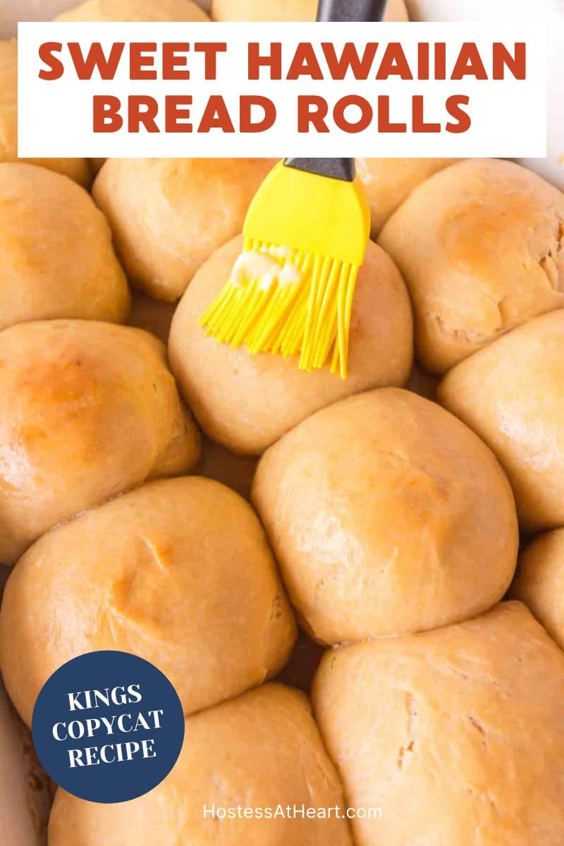 An image for pinterest of Pastry brush applying butter to the tops of baked hawaiian rolls - Hostess At Heart