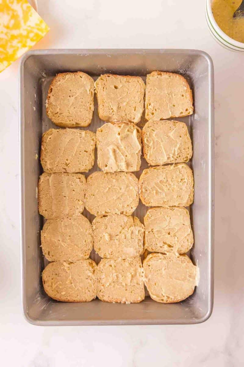 Butter mixture: bottom half of rolls spread with butter mixture made from melted butter, Dijon mustard, and garlic powder in a 9x13 pan. Hostess At Heart