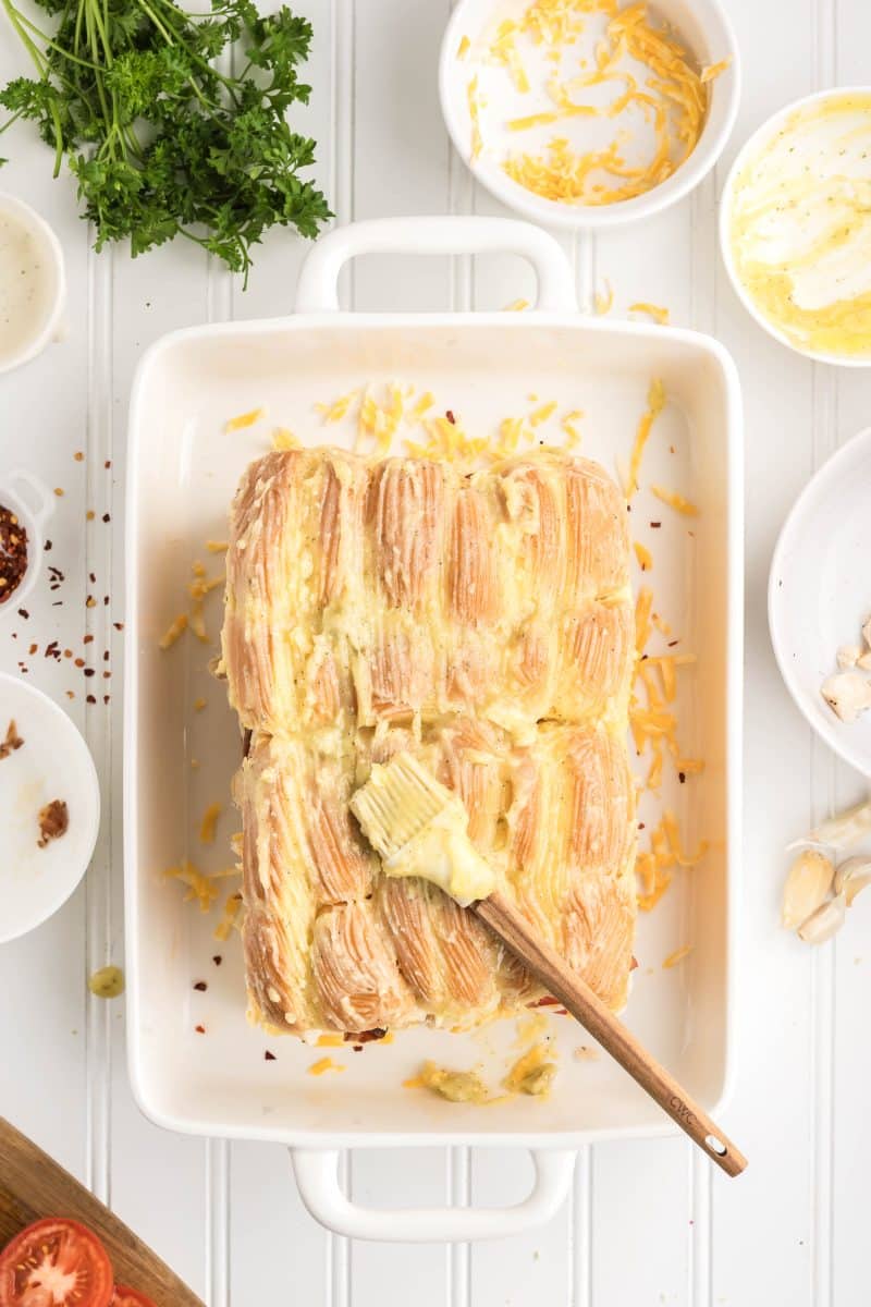 Unbaked bacon ranch chicken sliders with garlic butter brushed on tops, ready to go into the oven. Hostess At Heart