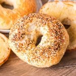 A freshly baked everything bagel propped up against other freshly baked bagels - Hostess At Heart