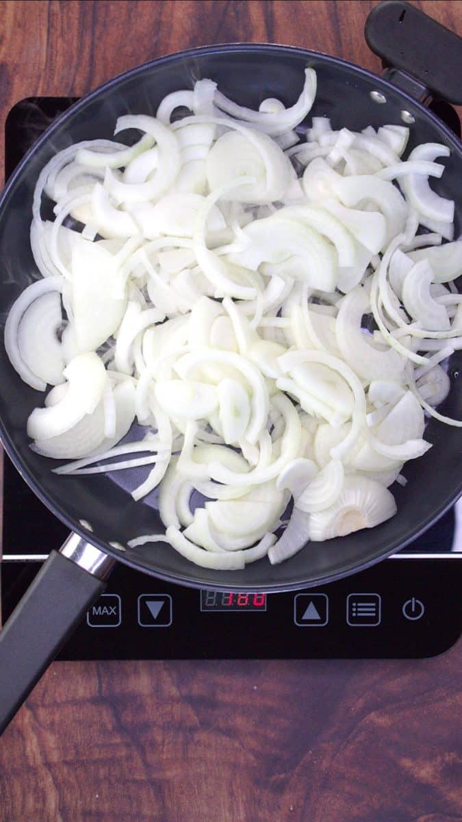 Freshly sliced onions in a skillet preparing to brown. Hostess At Heart