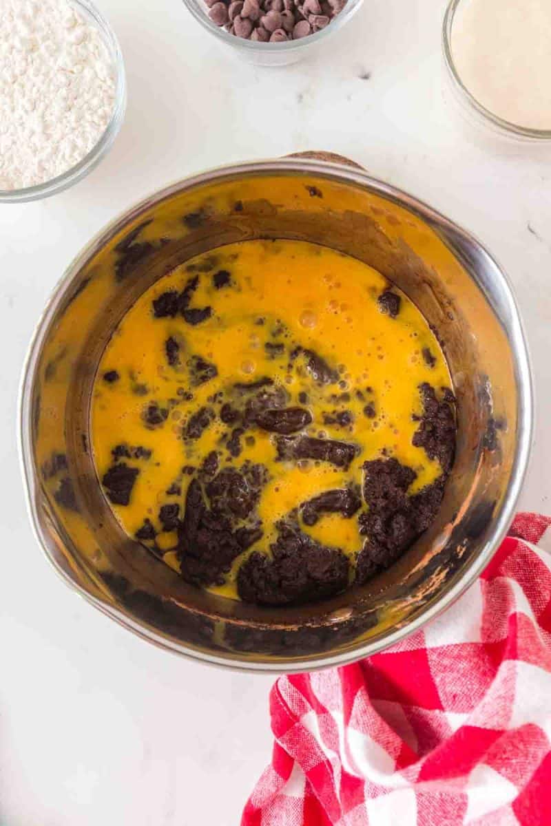 Whisking eggs into cooled chocolate brownie mixture - Hostess At Heart