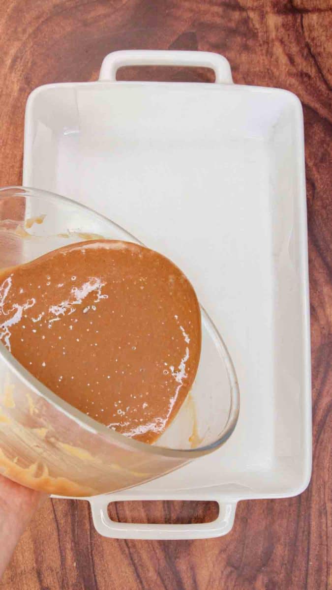 Chocolate Brownie batter being poured into a baking dish - Hostess At Heart