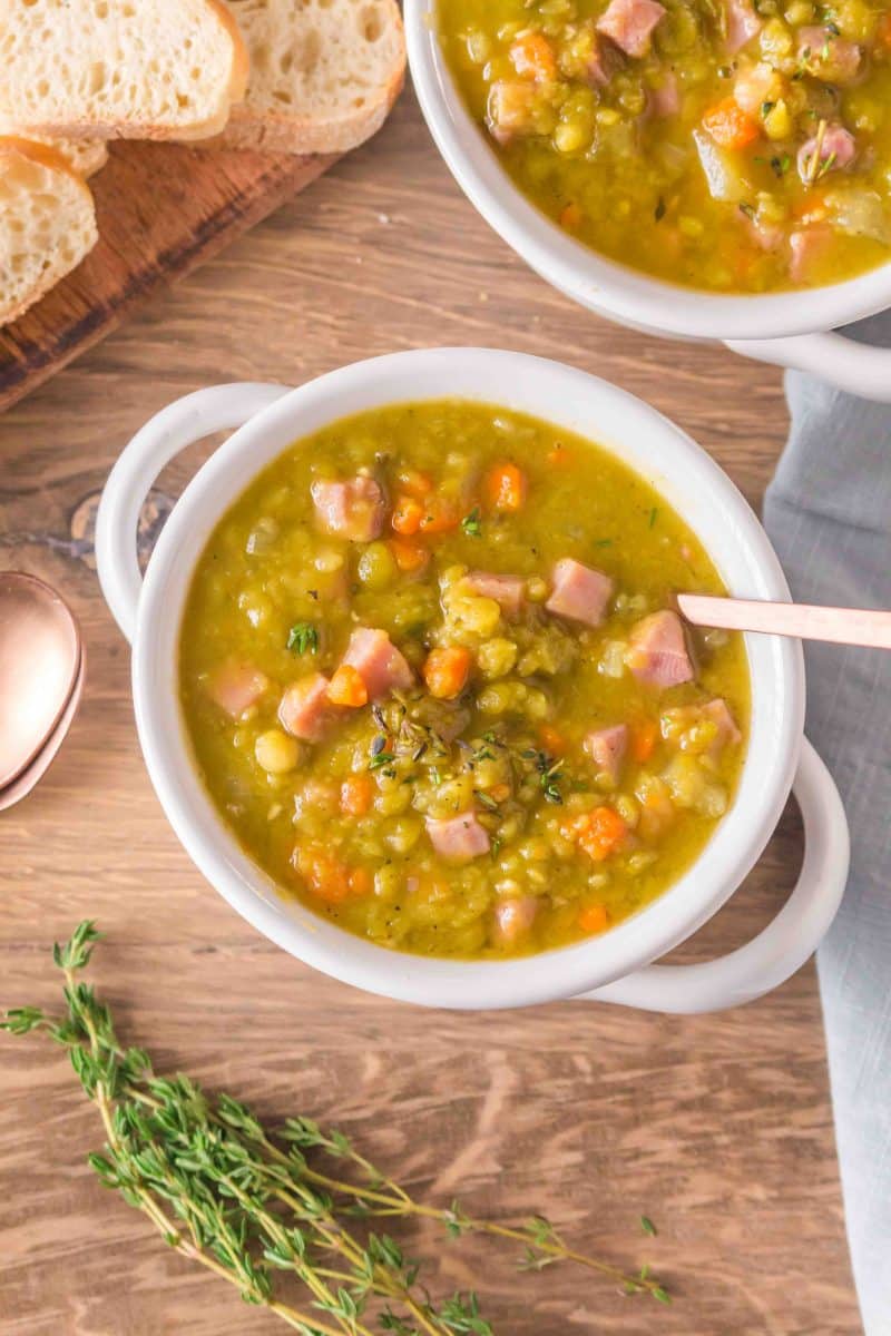 Top view of split pea and ham soup in a white bowl showing the hearty texture with ham pieces throughout. Hostess At Heart