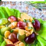 An image for Pinterest of a butter lettuce leaf filled with a grape salad with clementines dressed with poppyseed vinaigrette. Hostess At Heart