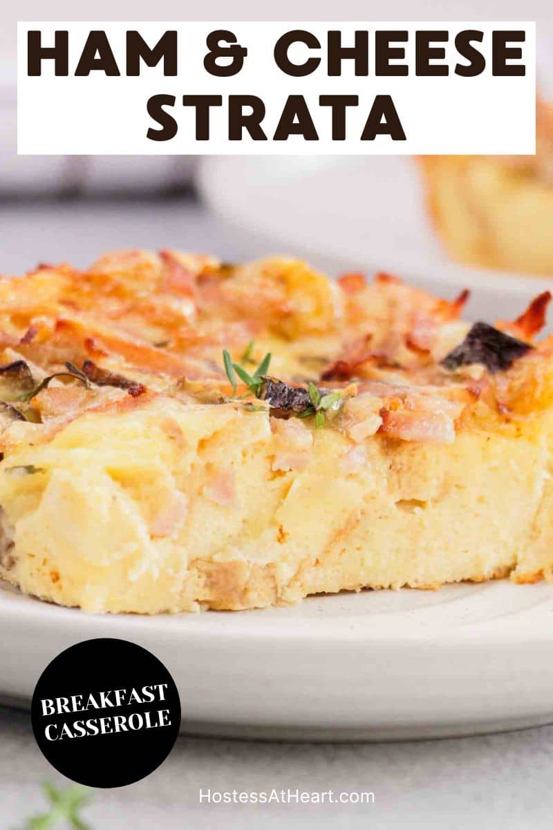 An image for Pinterest of a breakfast strata slice showing tender custardy bread, melted cheese, ham and mushrooms. Hostess At Heart