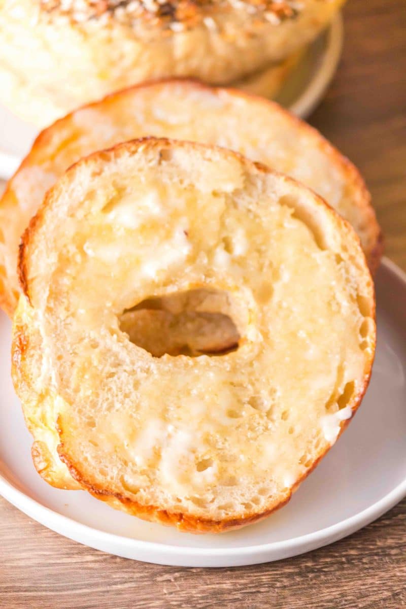 Tableview of a homemade sliced and toasted bagel with butter running down the warm interior. Hostess At Heart