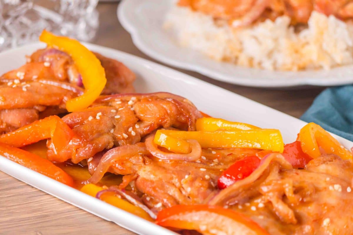 White platter of baked honey garlic chicken garnished with sesame seeds - Hostess At Heart