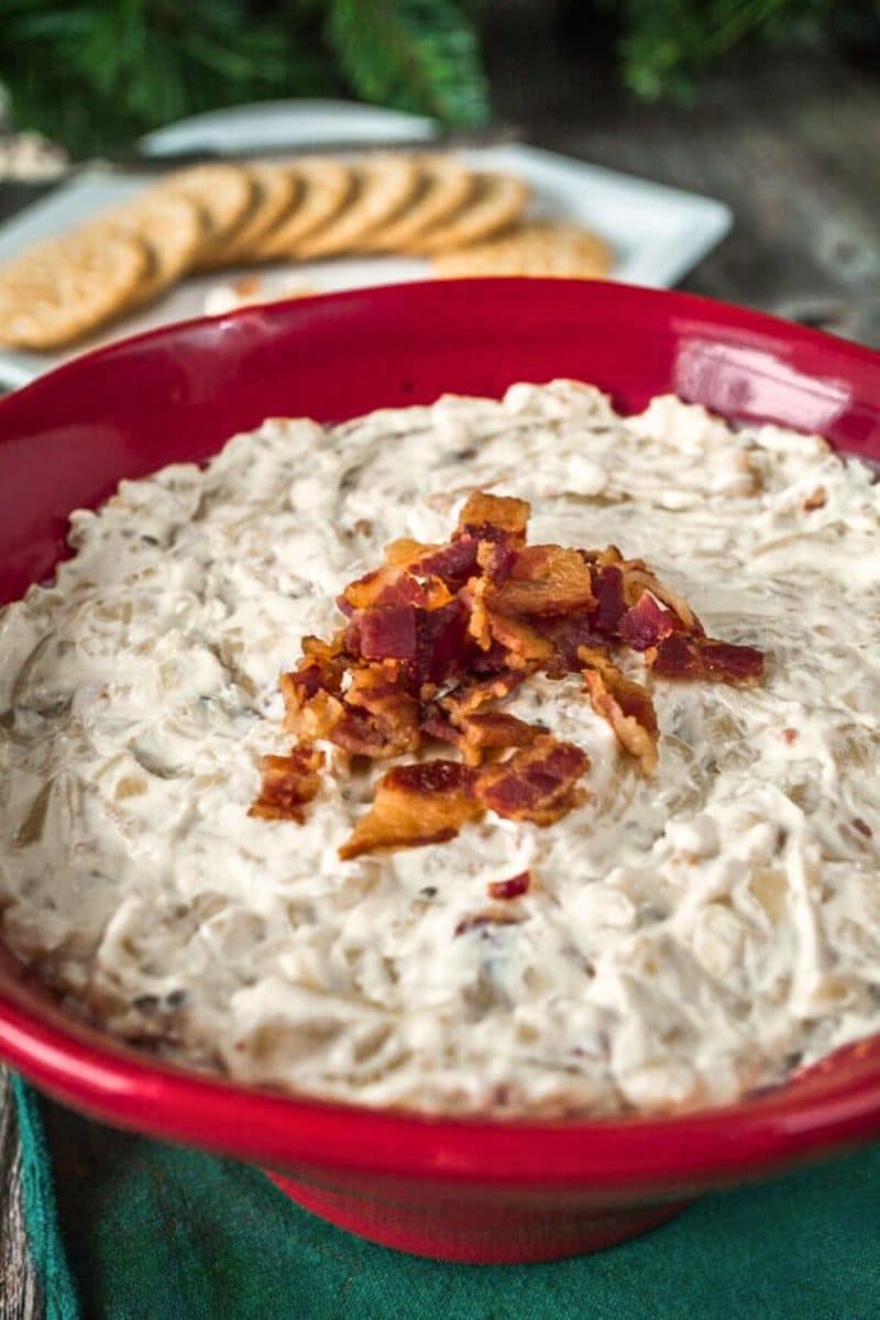 Caramelized onion bacon dip with crackers behind the bowl. Hostess At Heart