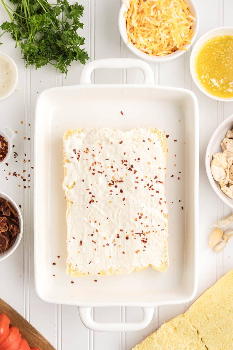 Unbaked chicken bacon ranch sliders with garlic butter brushed on tops, ready to go into the oven. Hostess At Heart