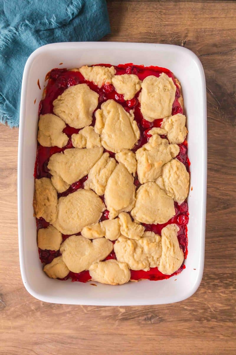 Overhead view of Cherry Pie Bars with a crumb topping fresh from the oven before adding a vanilla glaze drizzle. Hostess At Heart