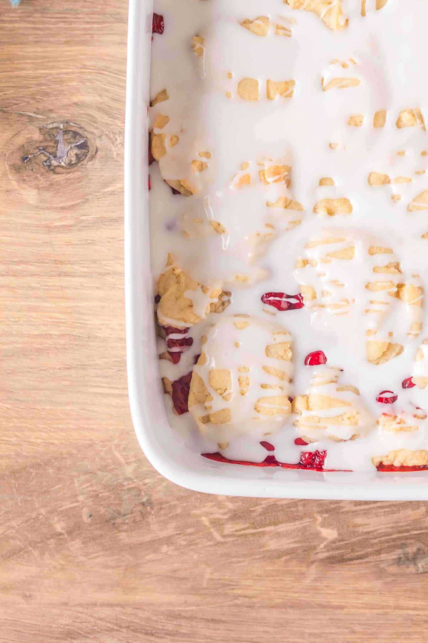 Overhead view of 3/4 of a 9x13 pan of Cherry Pie Bars, glazed and ready to serve. Hostess At Heart