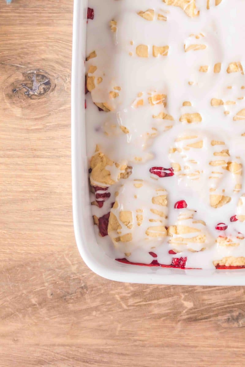 Overhead view of 3/4 of a 9x13 pan of Cherry Pie Bars, glazed and ready to serve. Hostess At Heart