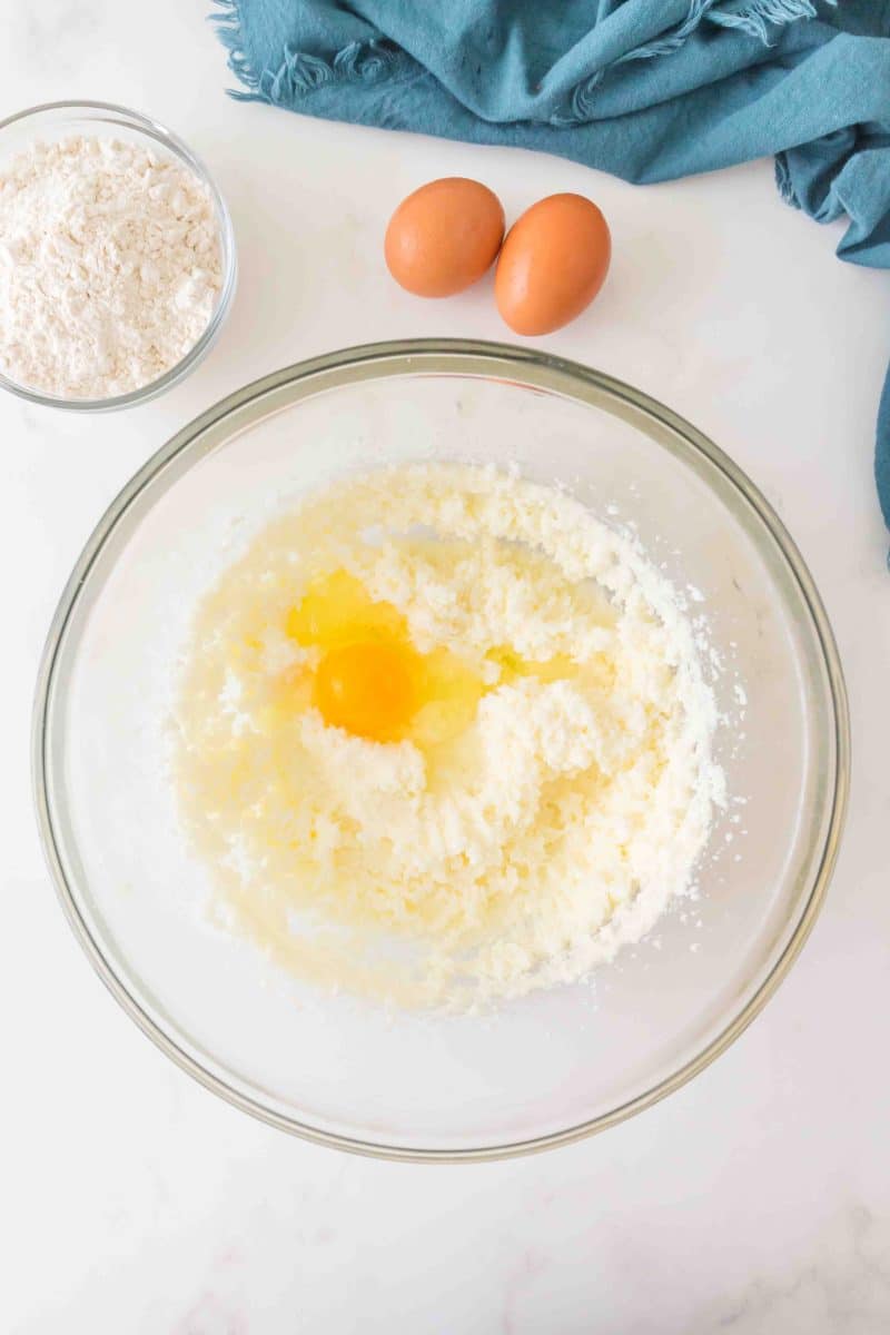 An egg added to a mixing bowl filled with Cherry Bar ingredients. Hostess At Heart
