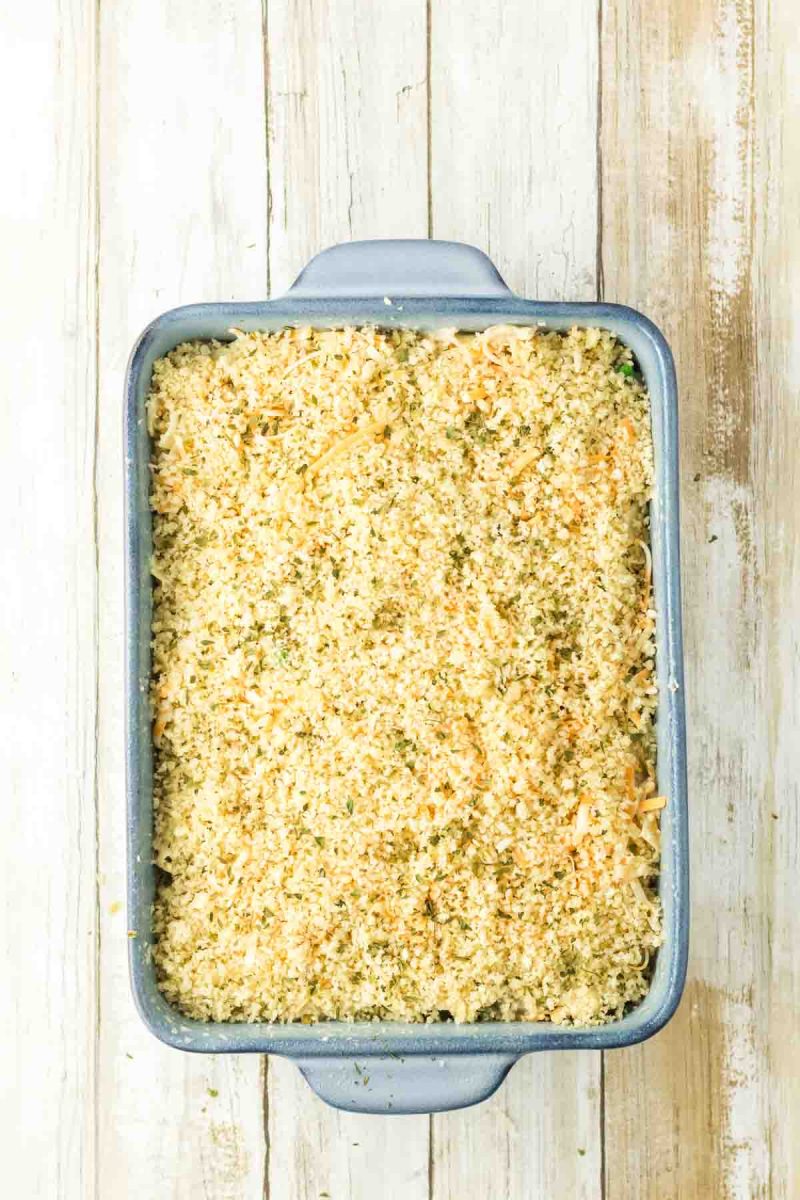 A tuna casserole assembled in a baking dish topped with buttered panko breadcrumb topping ready for the oven. Hostess At Heart