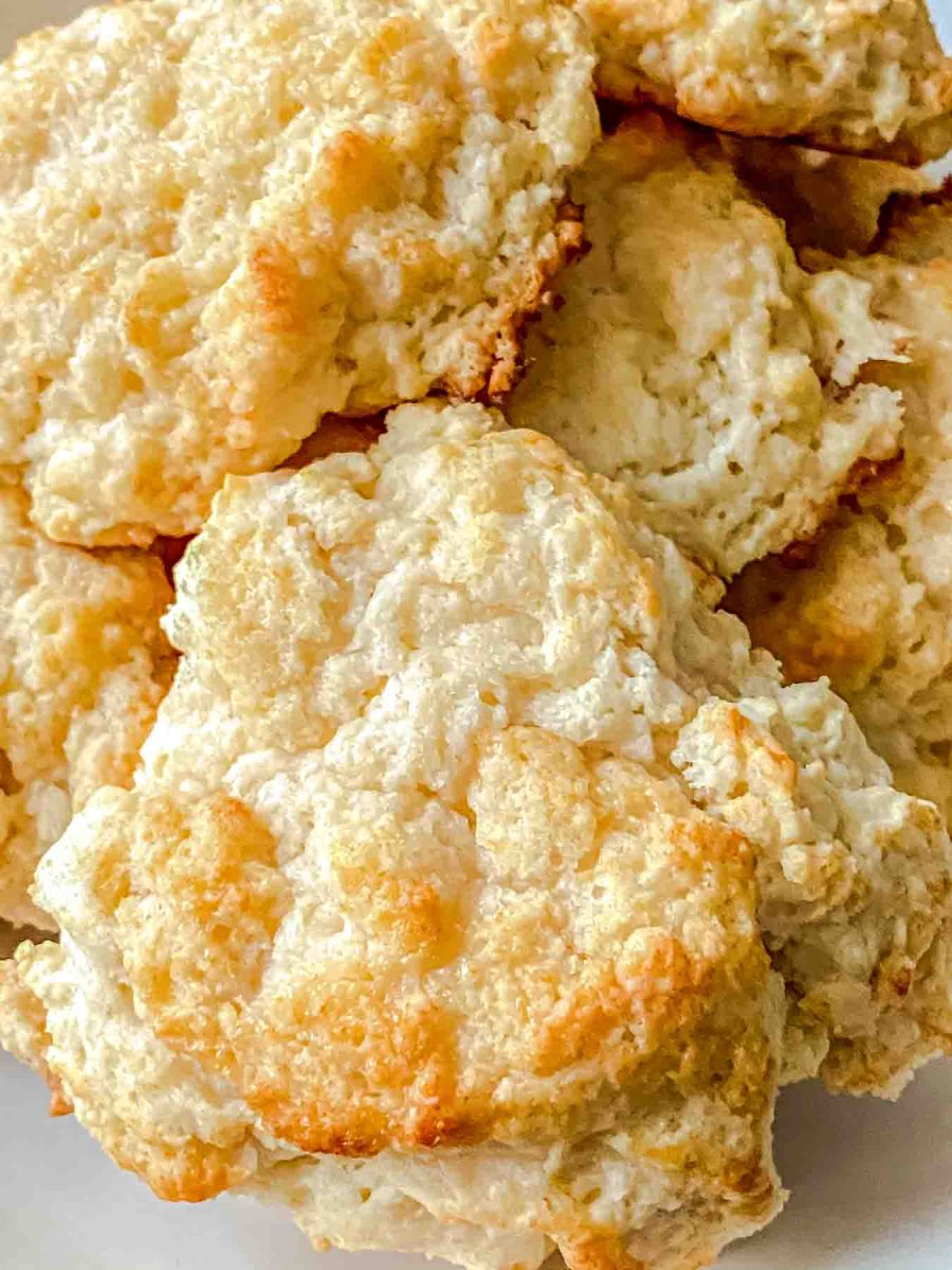 Closeup view of a pile of honey butter biscuits with honey butter glaze fresh from the oven - Hostess At Heart
