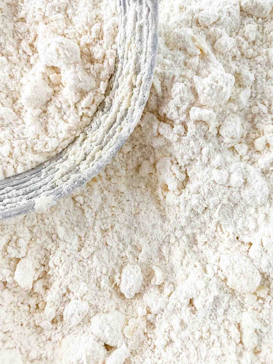 A pastry cutter cutting cold butter into flour in order to make fluffy homemade biscuits from scratch - Hostess At Heart