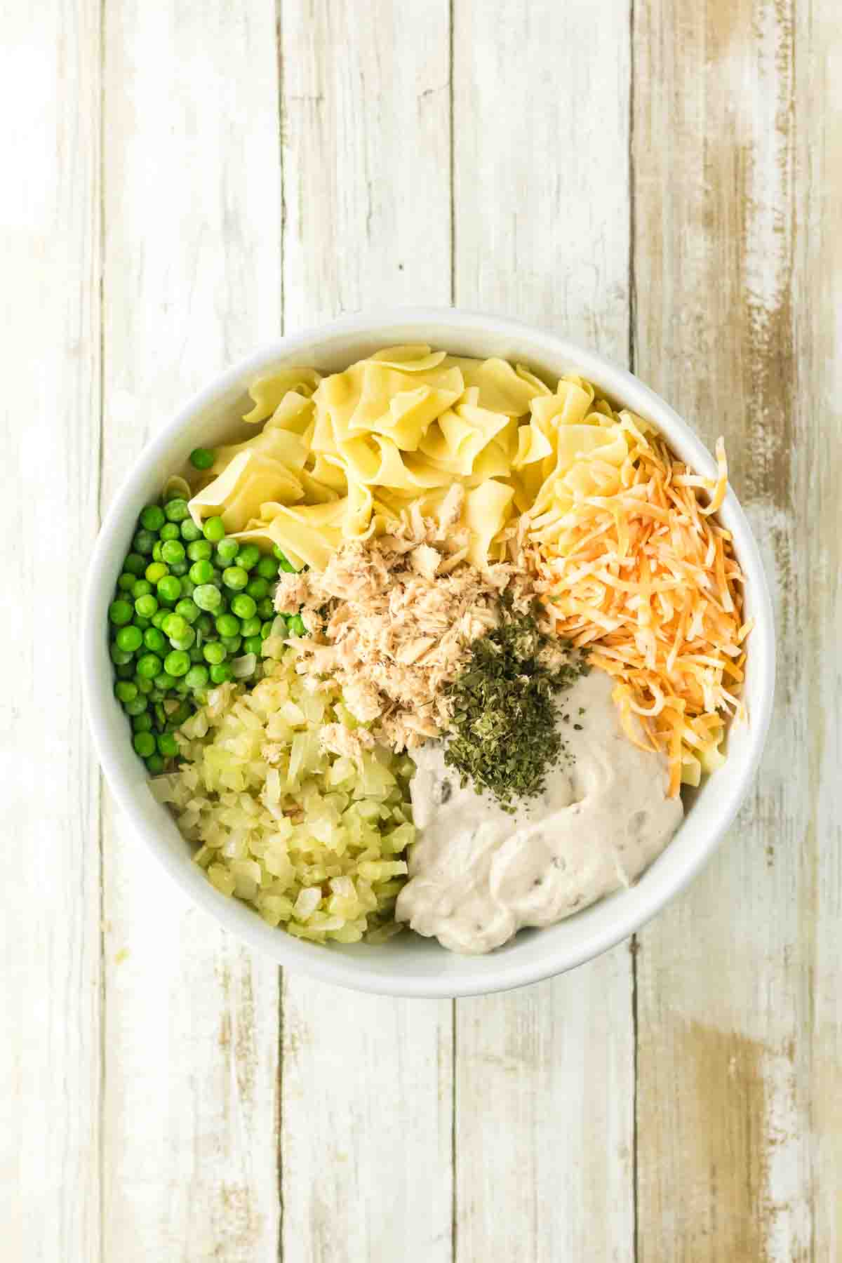Bowl of tuna and noodle casserole ingredients ready to mix and put into a baking dish. Hostess At Heart