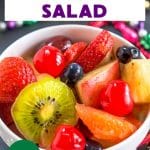 Bright colorful fruit in a white bowl mixed with alcohol to make a Mardi Gras Hurricane salad. Hostess At Heart
