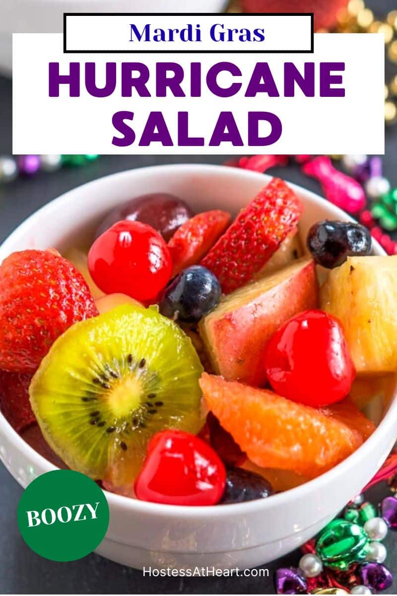 Bright colorful fruit in a white bowl mixed with alcohol to make a Mardi Gras Hurricane salad. Hostess At Heart