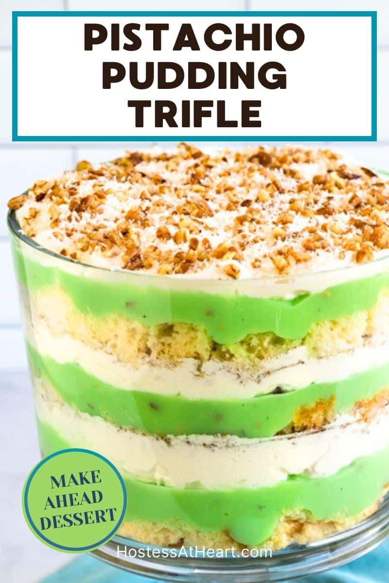 An image for Pinterest of a trifle bowl filled with layers of angelfood cake, pistachio cake, and whipped cream for an easy make-ahead St. Patrick's Dessert. Hostess At Heart