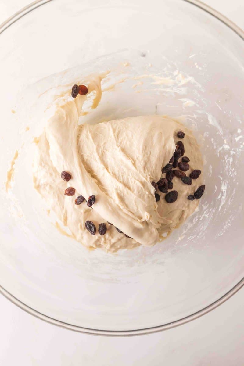 Sticky sourdough bread dough in a mixing bowl with dark raisins folded throughout - Hostess At Heart