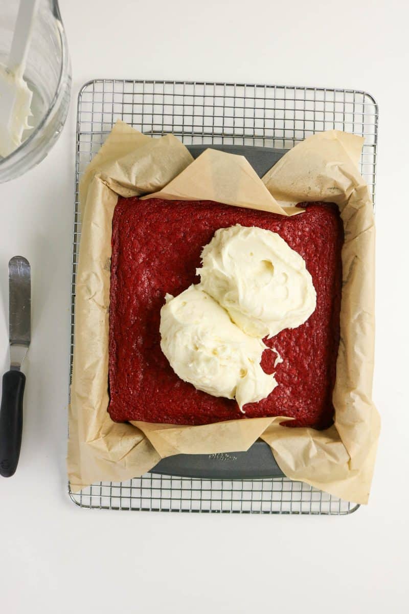 Cream cheese frosting on red velvet brownies preparing to be spread. Hostess At Heart