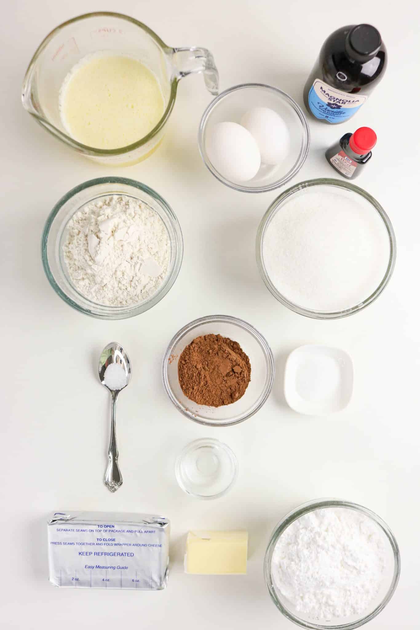 Ingredients for red velvet brownies including butter, sugar, cocoa powder, eggs, red food coloring, and cream cheese. Hostess At Heart