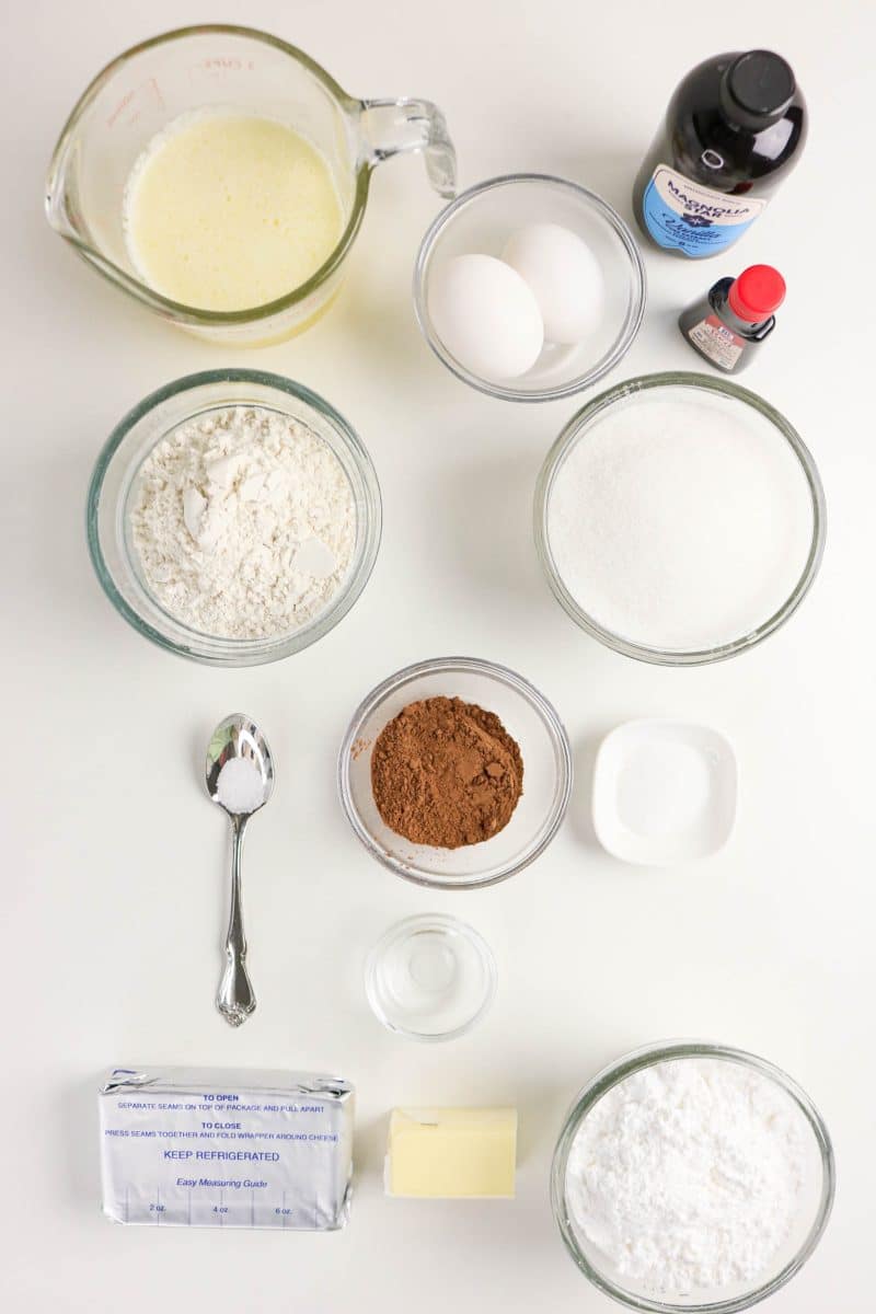Ingredients for red velvet brownies including butter, sugar, cocoa powder, eggs, red food coloring, and cream cheese. Hostess At Heart