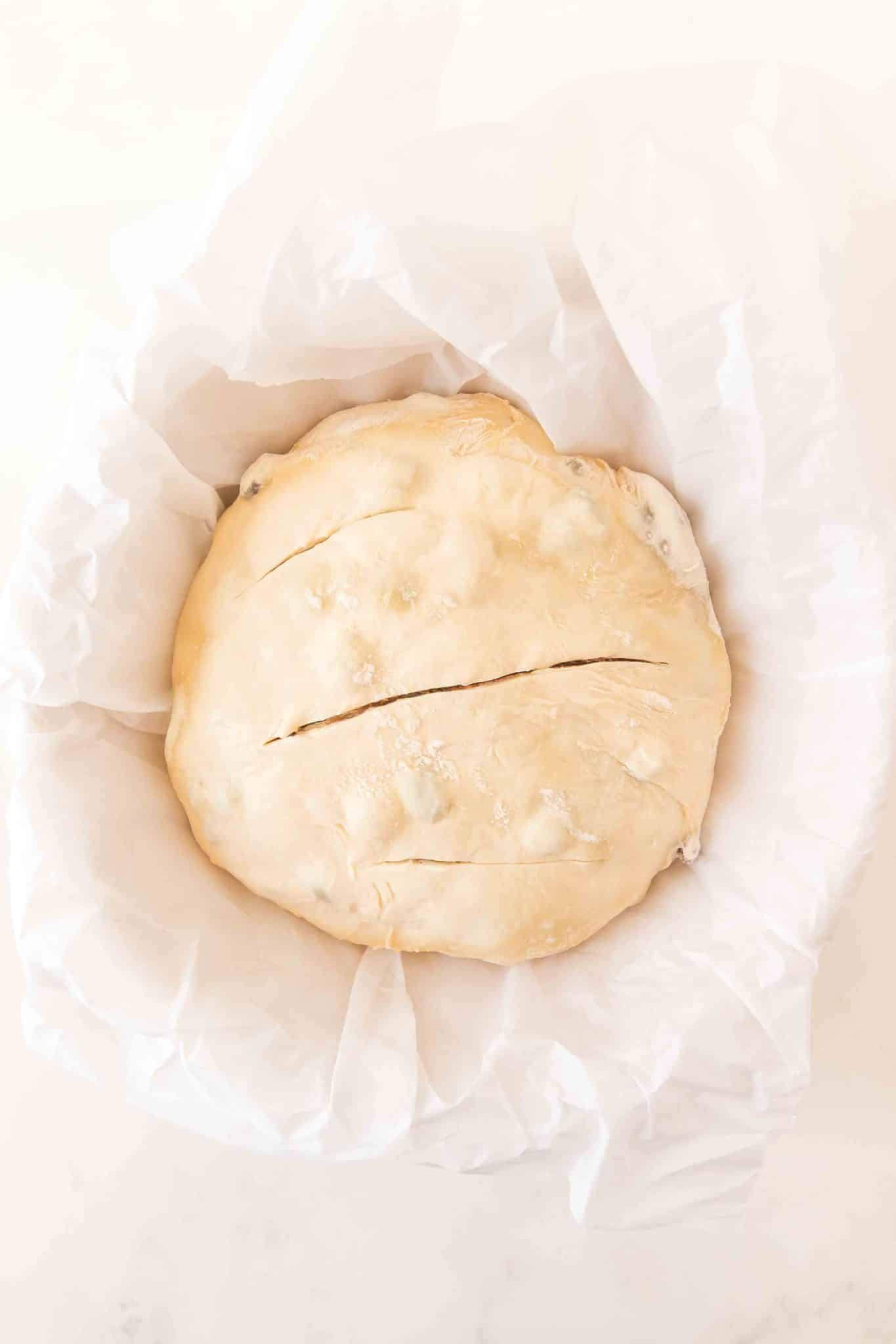 Sourdough cinnamon raisin bread scored three times on top, in a Dutch oven ready to go into the oven. Hostess At Heart