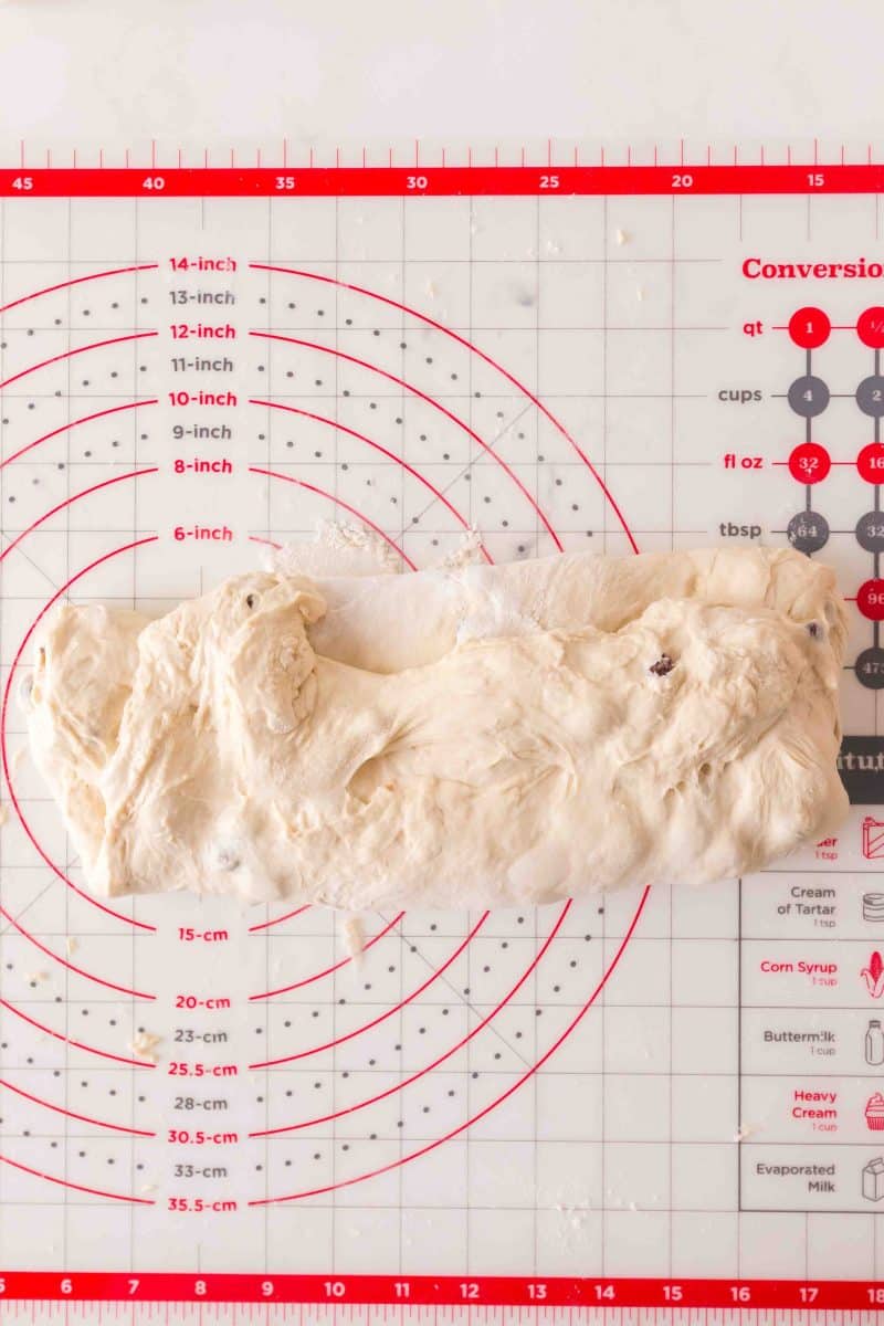 Shaped sourdough cinnamon raisin bread log sitting on a baking mat. Hostess At Heart