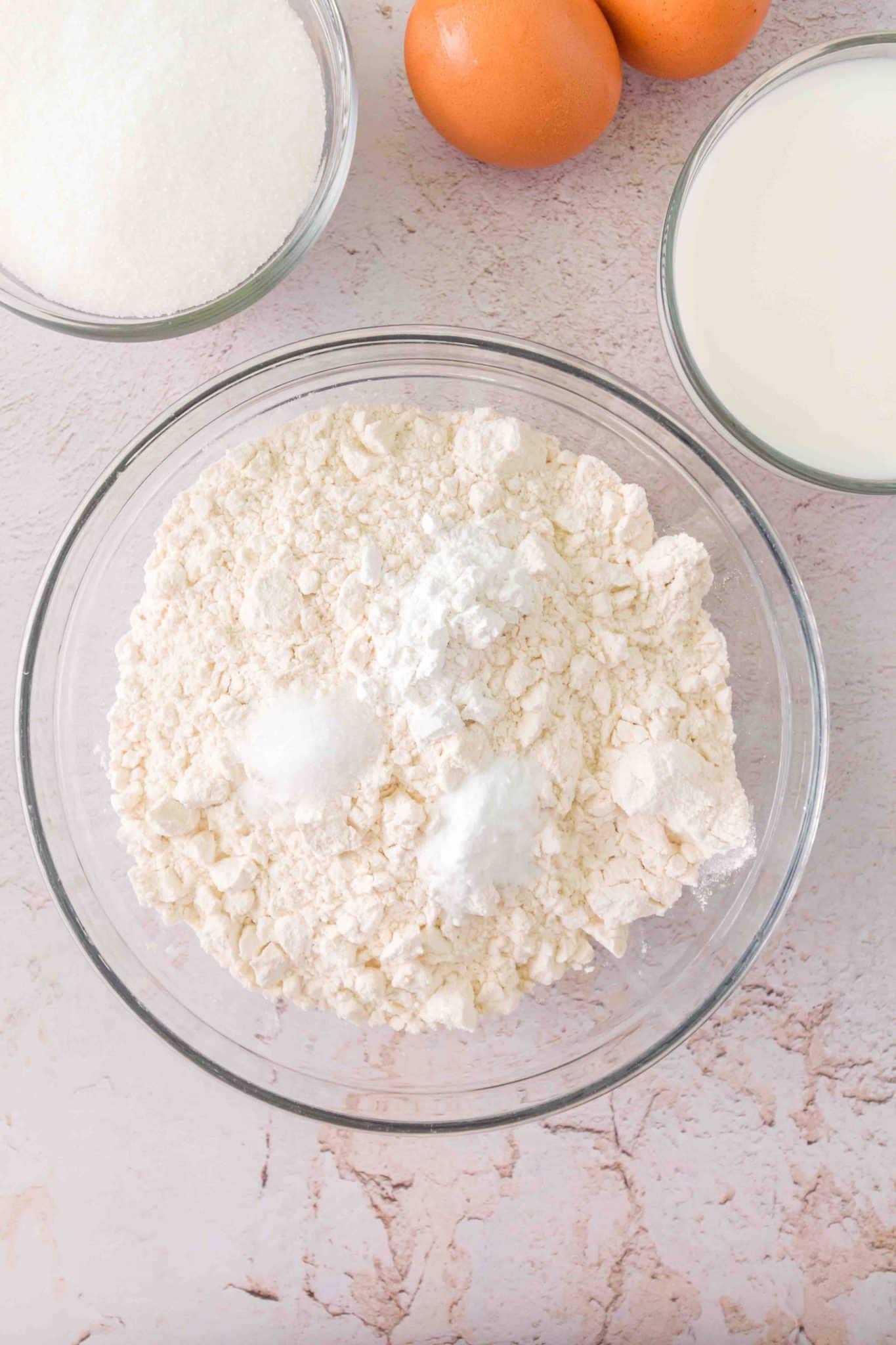 A mixing bowl filled with dry ingredients for homemade sourdough chocolate chip muffins including flour, baking powder and soda, and salt - Hostess At Heart