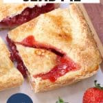 A top down view of a slice of easy slab pie with strawberry filling oozing out of the top crust. Hostess At Heart