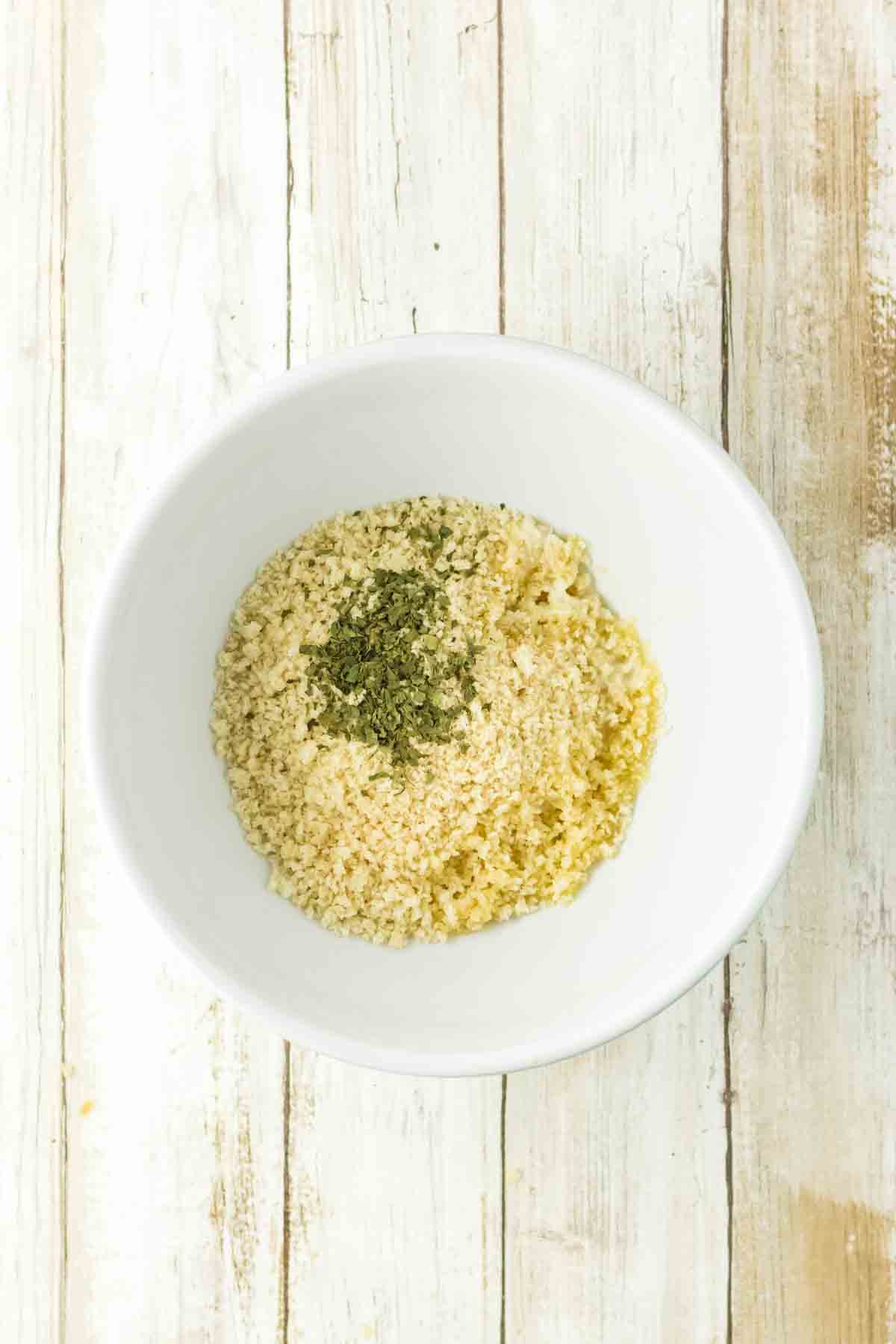 A small bowl filled with dried parsley and panko bread crumbs to make the topping for a tuna casserole recipe. Hostess At Heart