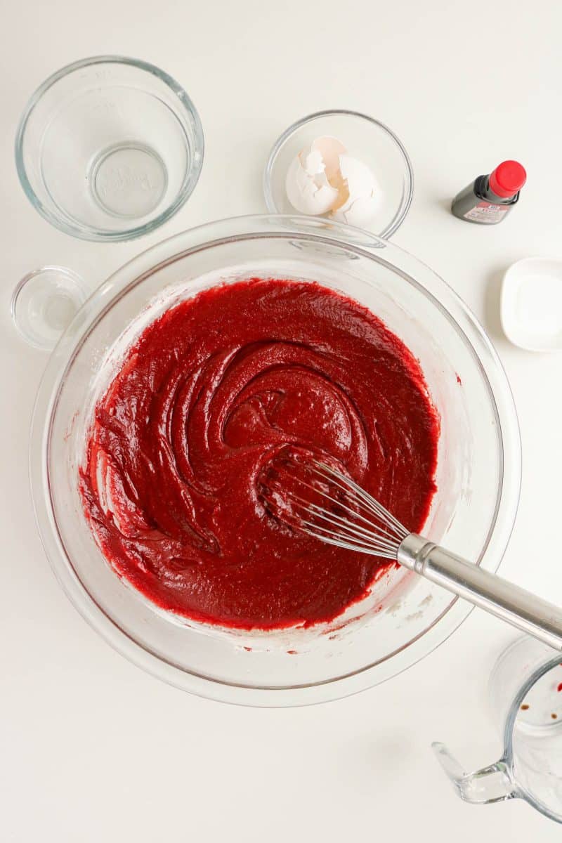 Red velvet brownie batter in glass bowl showing bright red color. Hostess At Heart