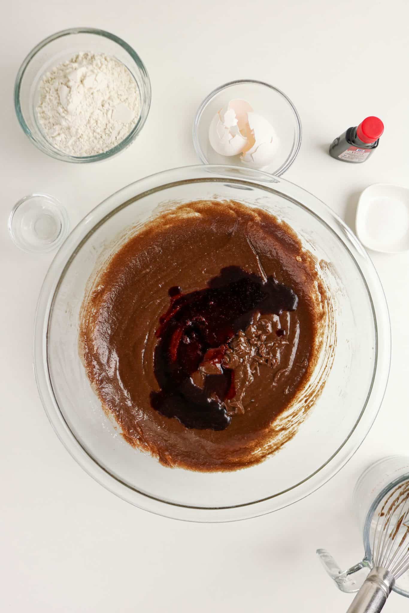 Red food color added to brownie batter in a mixing bowl to make easy red velvet brownies - Hostess At Heart