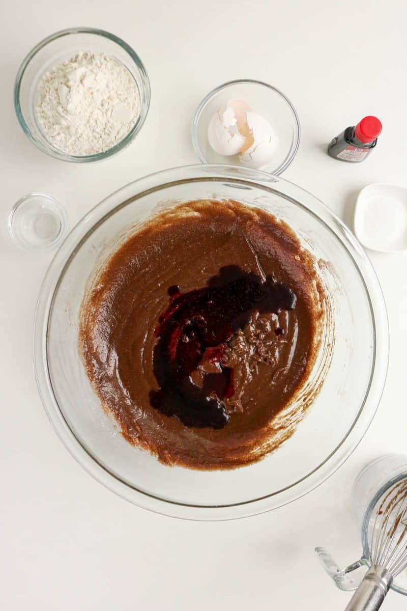 Red food color added to brownie batter in a mixing bowl to make easy red velvet brownies - Hostess At Heart