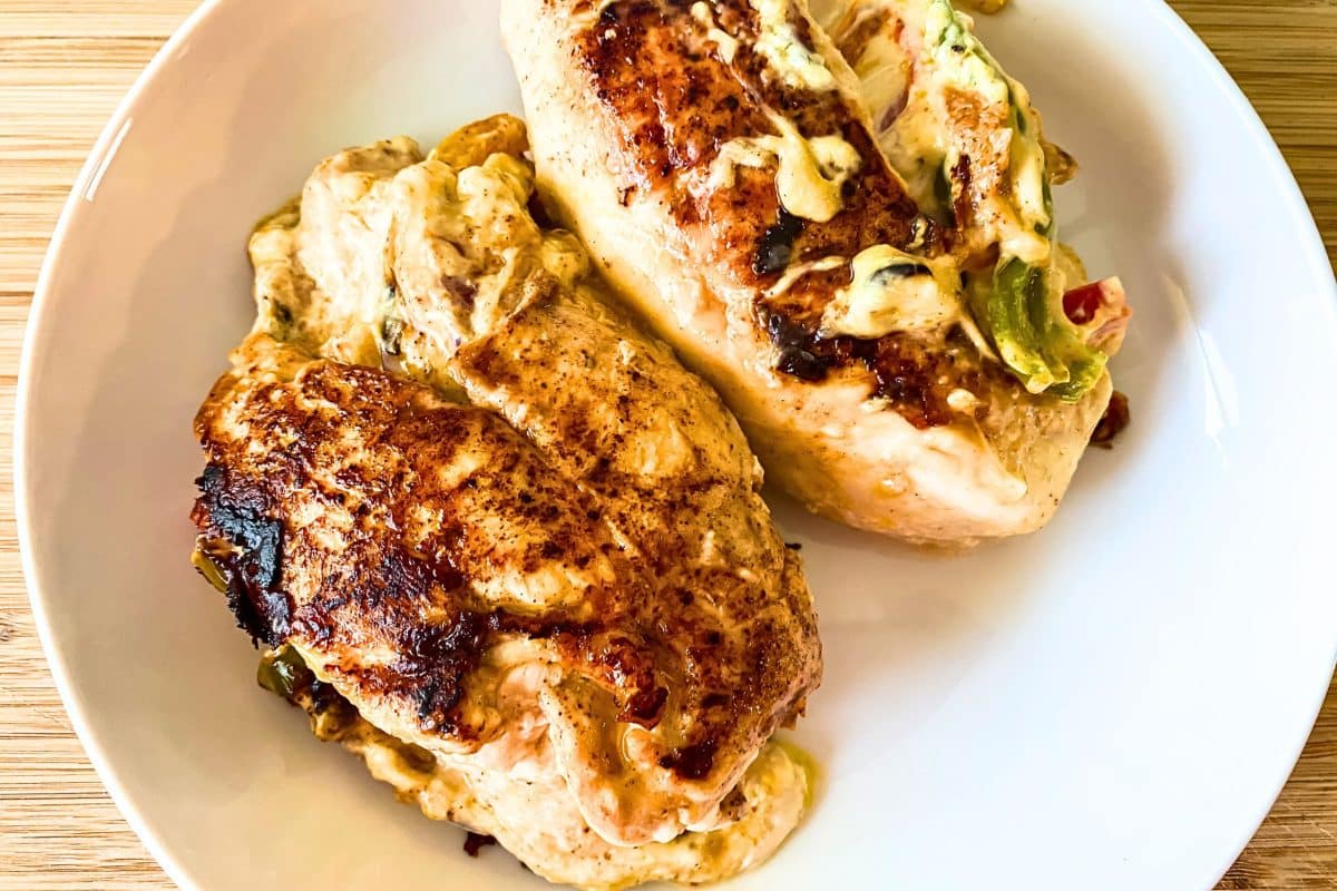 Top down view of baked golden brown chicken breasts stuffed with cheese and peppers - Hostess At Heart