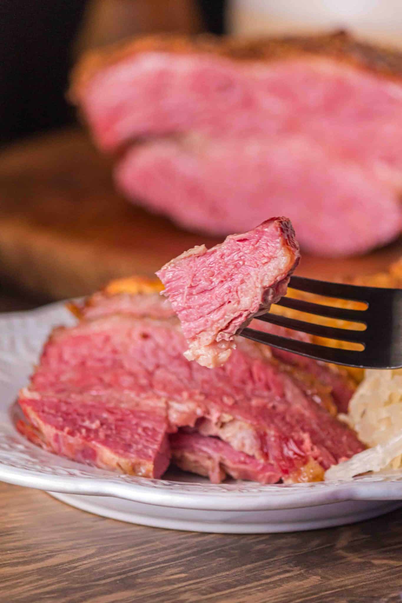 A fork filled with a juicy bite of oven roasted corned beef brisket. Hostess At Heart