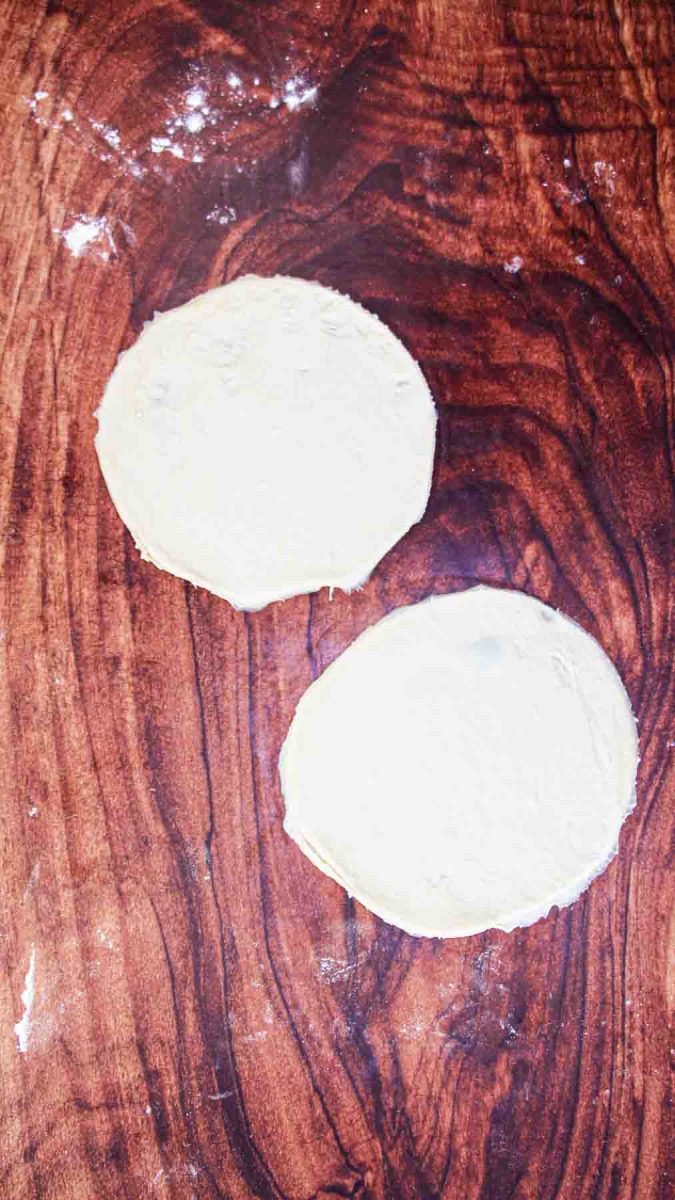 Pizza dough circles cut out on a wooden cutting board. Hostess At Heart