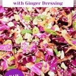 A titled image for Pinterest of a serving dish filled with an Asian Slaw Salad featuring raw purple cabbage, peppers, carrots, in a ginger sesame dressing garnished with cashews - Hostess At Heart