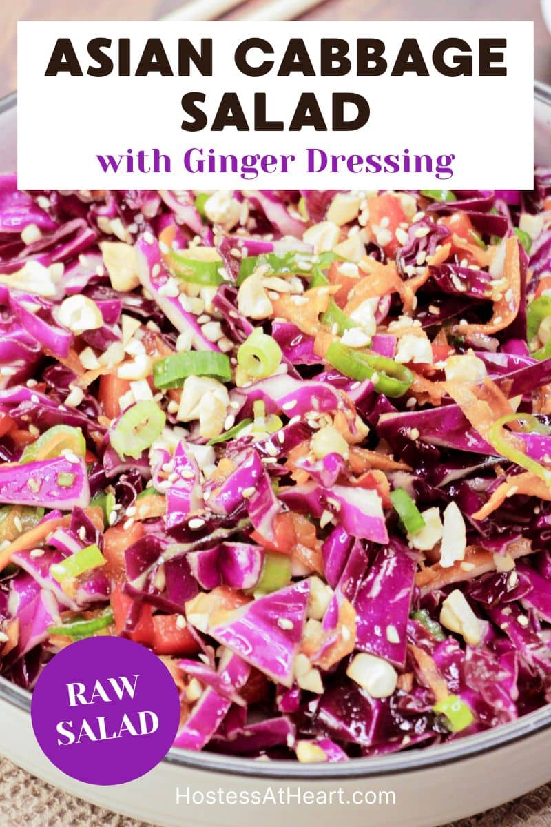 A titled image for Pinterest of a serving dish filled with an Asian Slaw Salad featuring raw purple cabbage, peppers, carrots, in a ginger sesame dressing garnished with cashews - Hostess At Heart