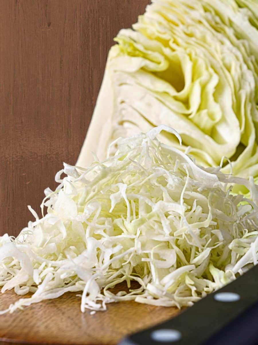 Shredded cabbage for a corned beef sandwich sitting on a cutting board. Hostess At Heart