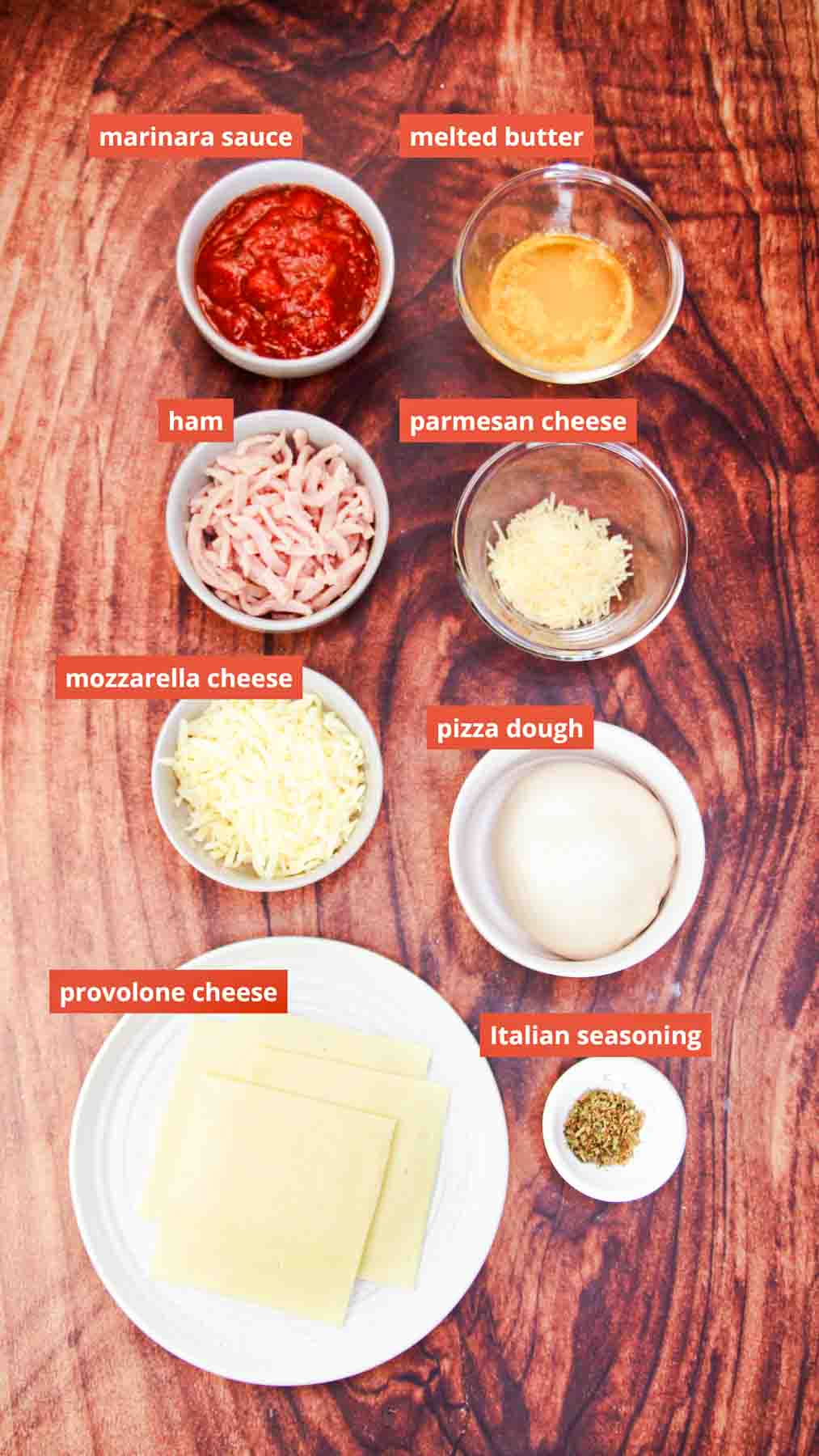 Ingredients image for "Easy Calzone Recipe" including provolone cheese, Italian seasoning, pizza dough, mozzarella cheese, parmesan cheese, butter, ham, and marinara. Hostess At Heart