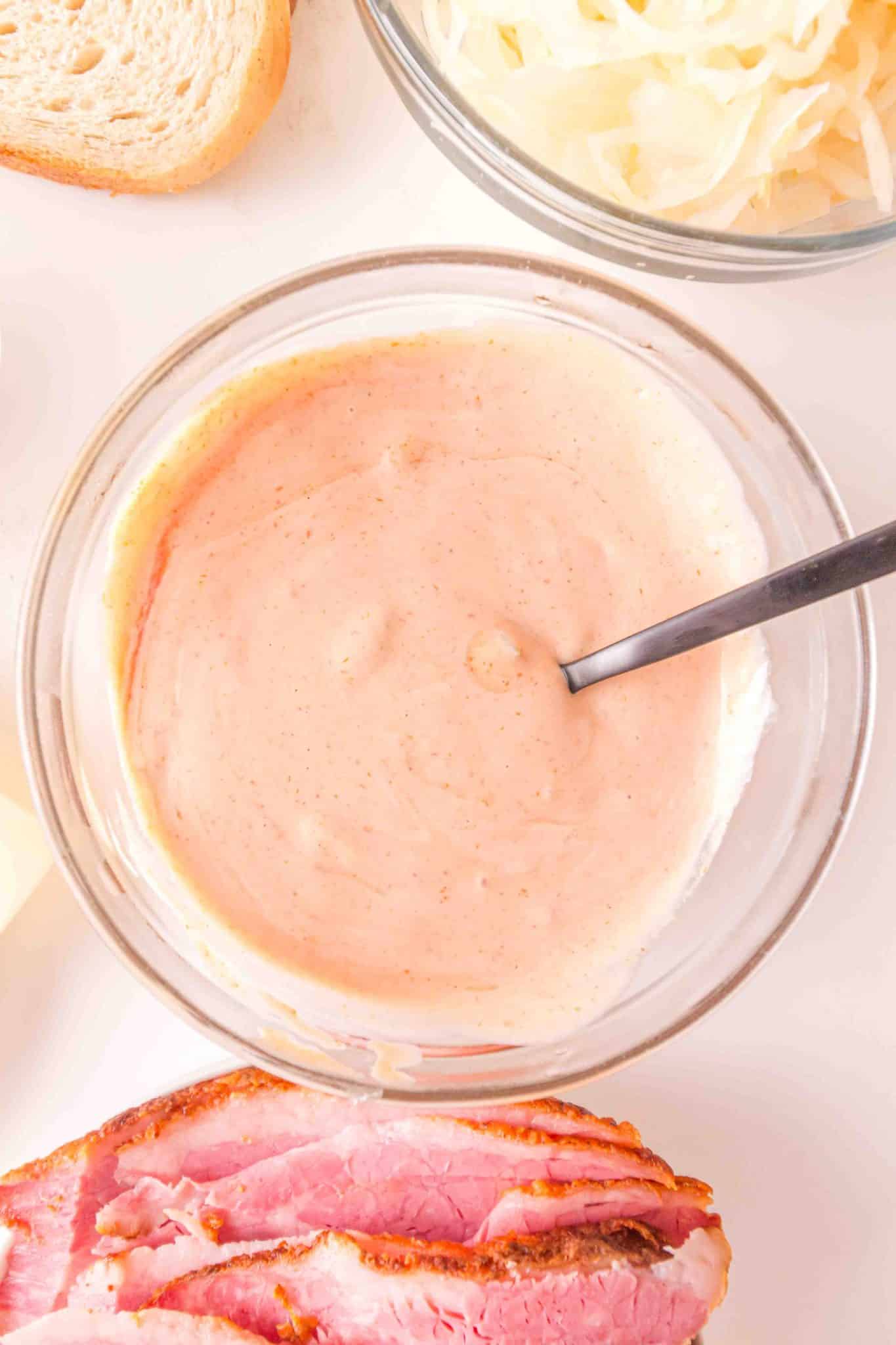 A top down view of a mixing bowl filled with homemade Thousand Island dressing. Hostess At Heart
