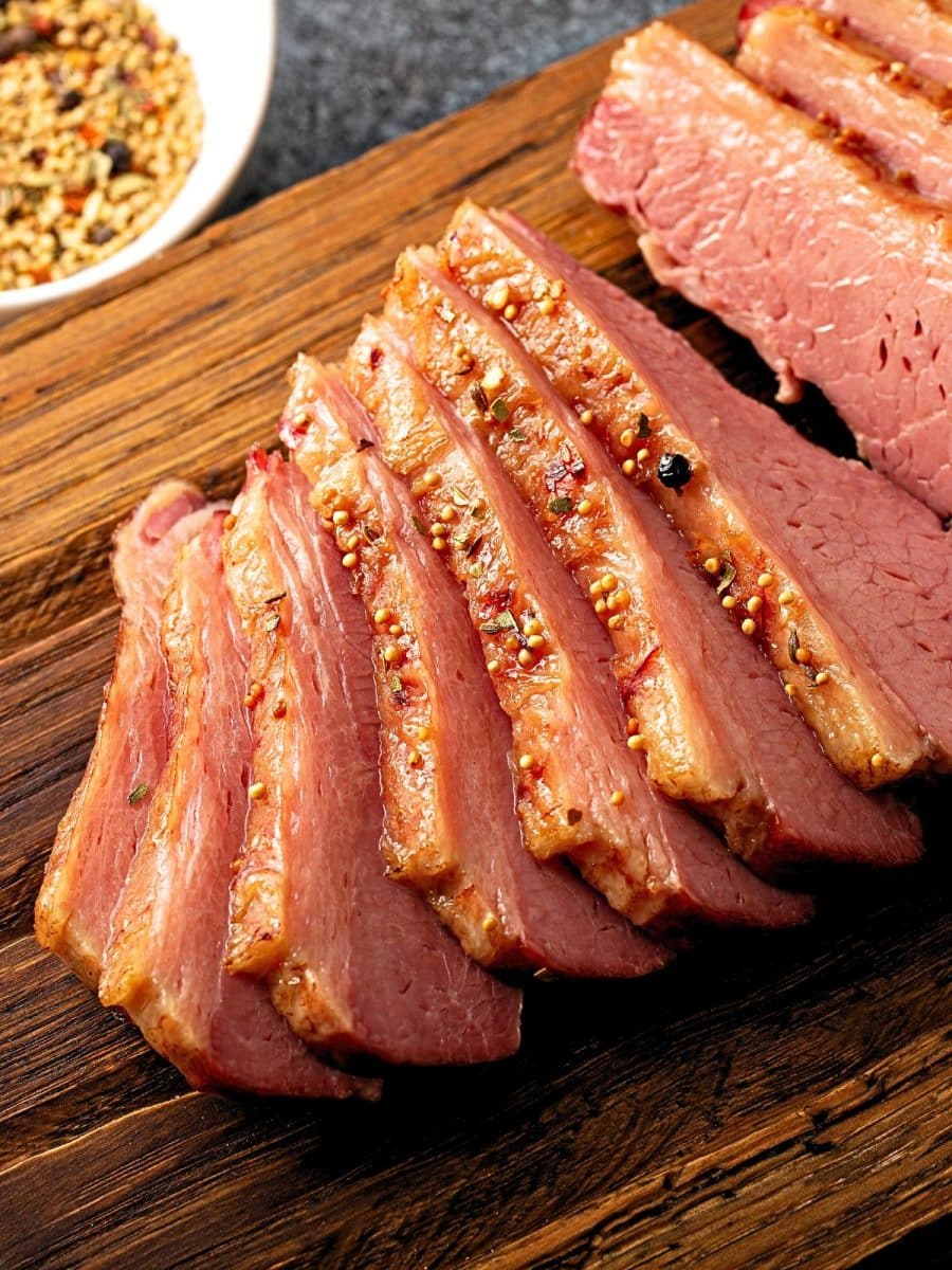 Sliced corned beef on a wooden cutting board. Hostess At Heart