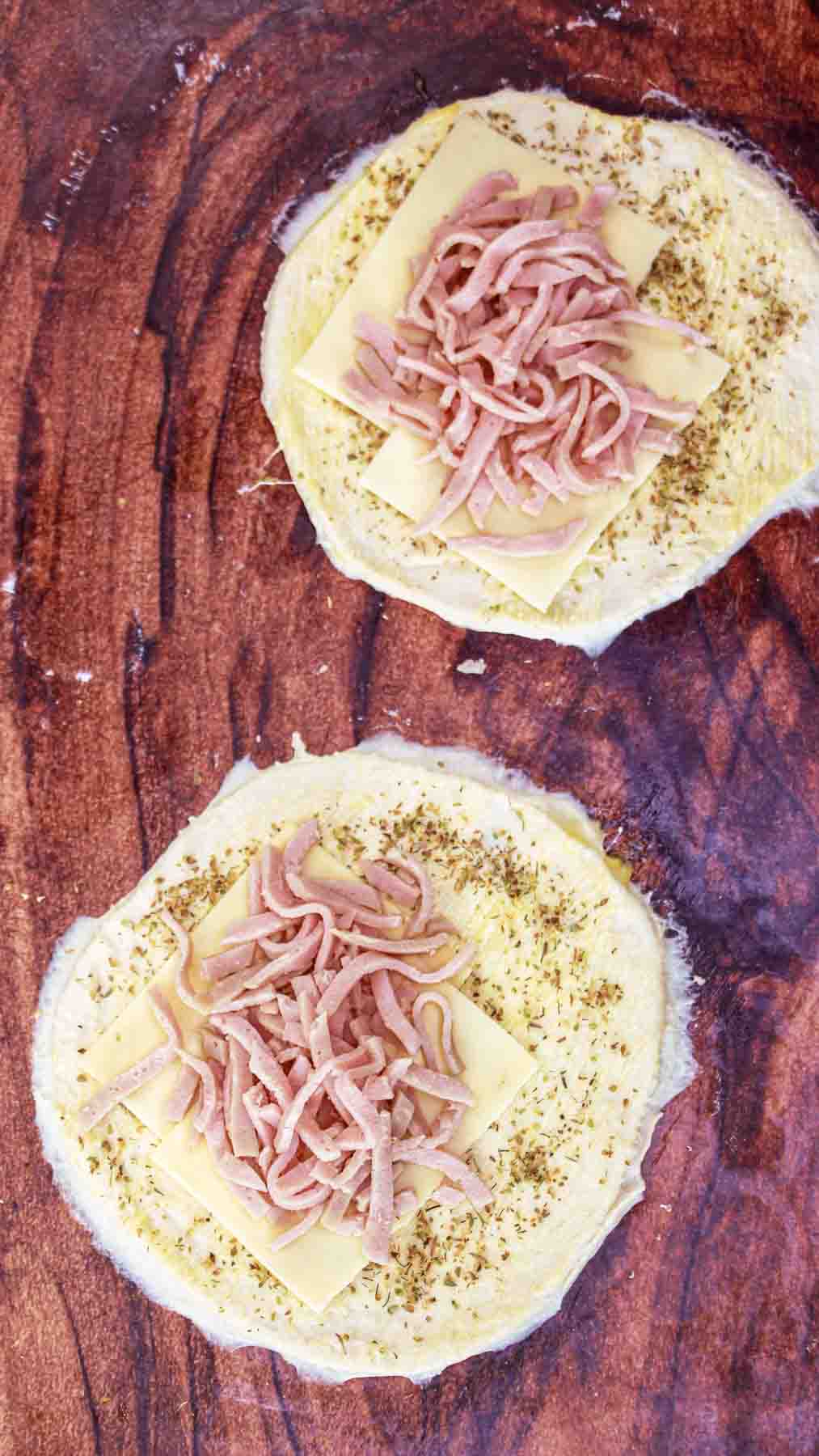 Layers of filling on a cut pizza dough circles before folding. Hostess At Heart