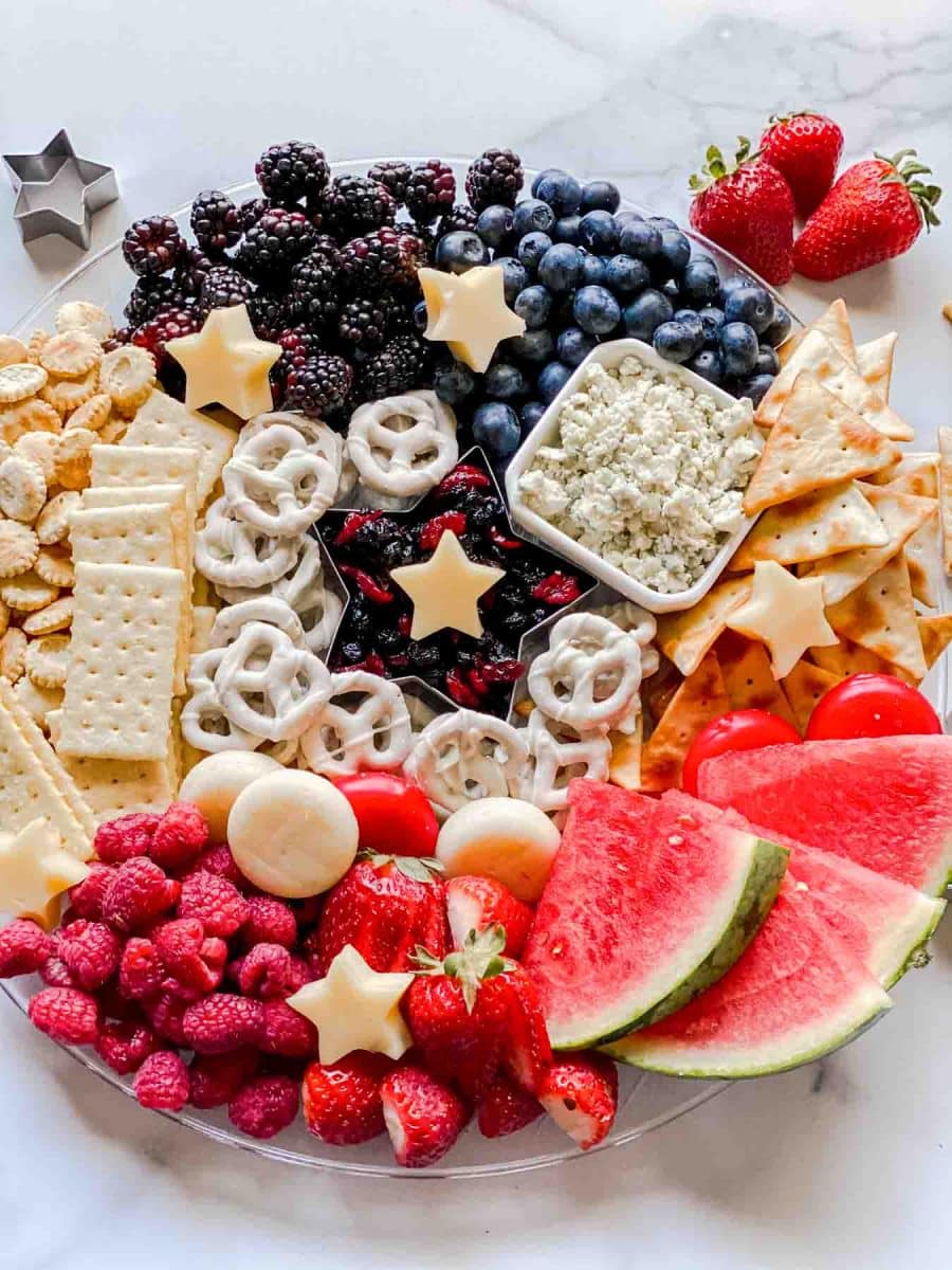 Top down view of a 4th of July Charcuterie Board filled with cheeses, fruits and crackers. Hostess At Heart